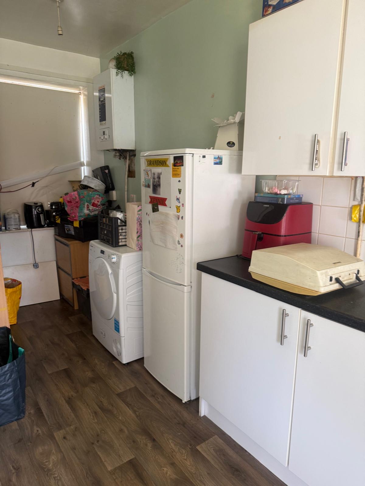 Kitchen corner before: green walls, dated tiling, crowded worktop