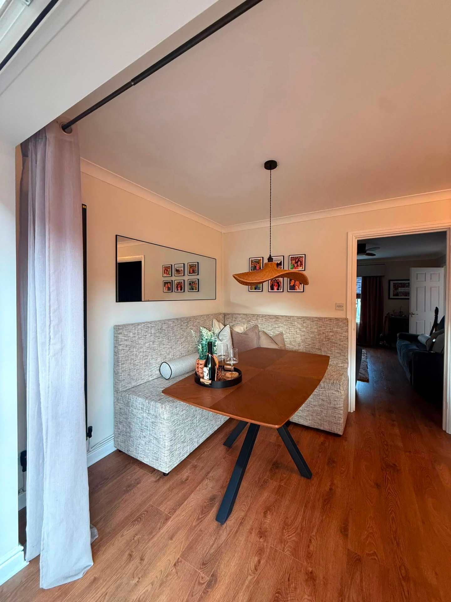 The new dining nook: upholstered corner bench, wooden table and rattan pendant light
