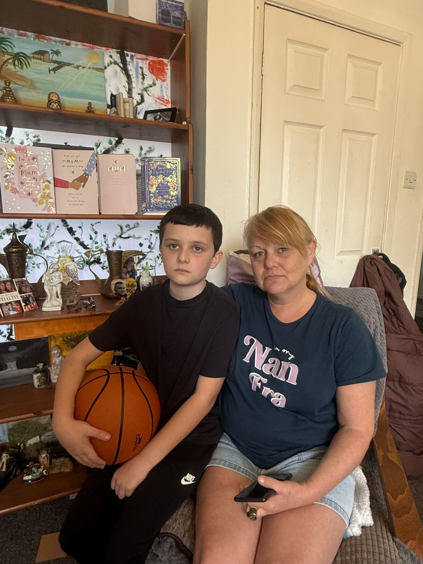 Joni sat with her grandson in the family living room before the transformation, surrounded by photographs and keepsakes of Kennie