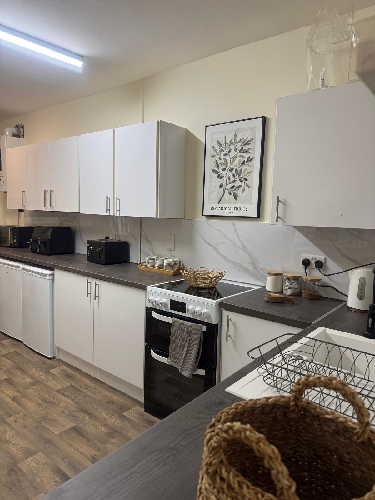 Kitchen corner after: marble splashback, new oven, botanical print and styled shelves