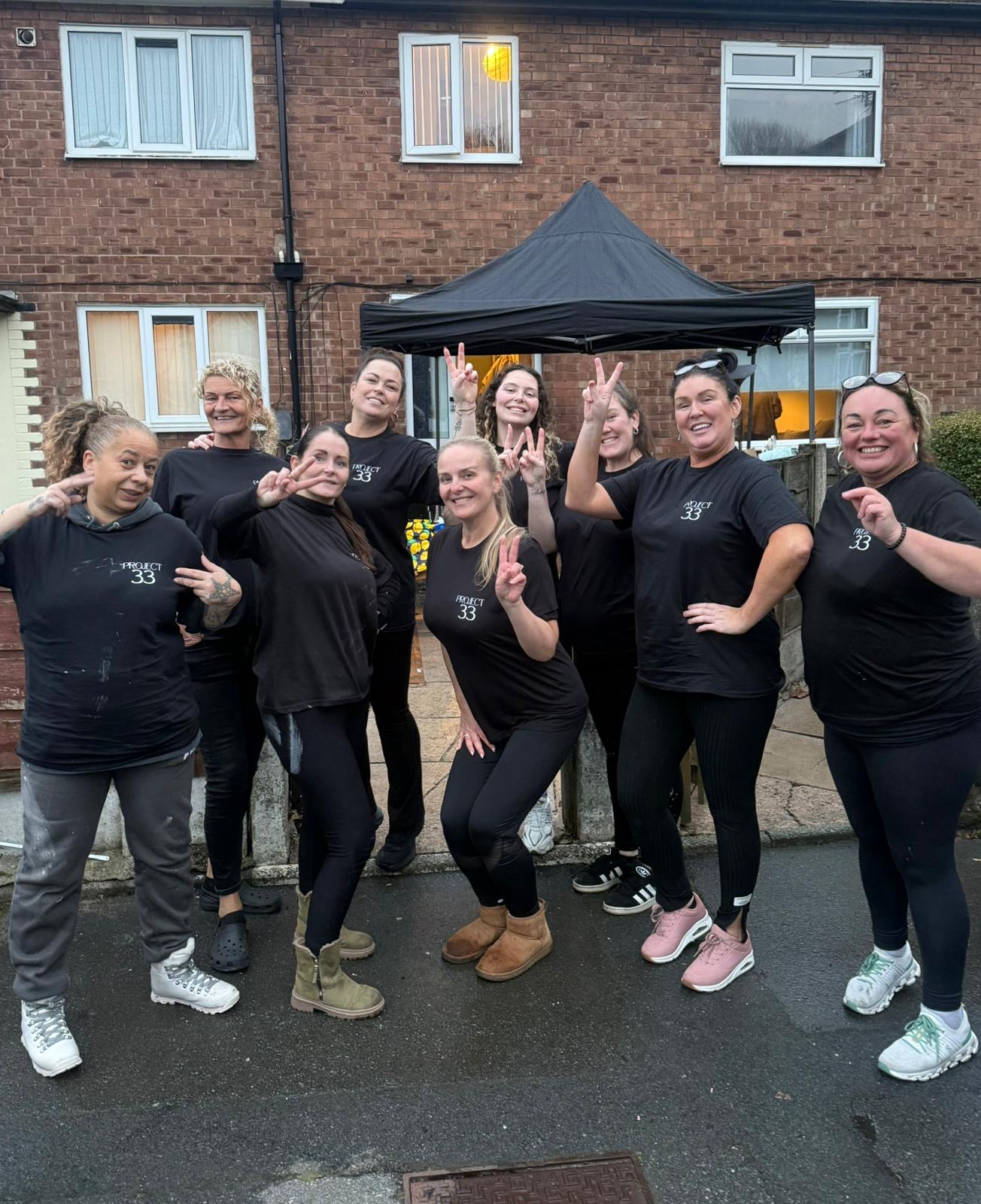 The Project 33 volunteer team in matching t-shirts outside Beth's home