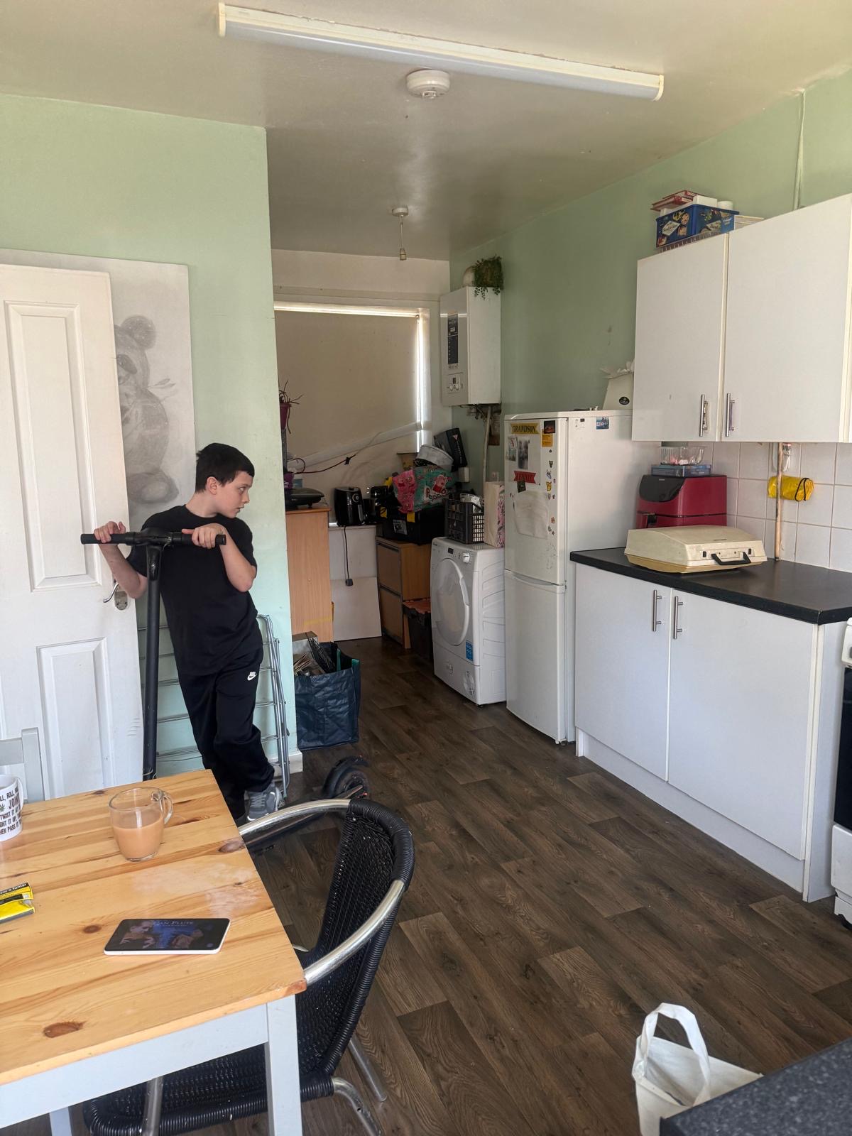 Kitchen before: tired walls, mismatched appliances, cluttered worktops